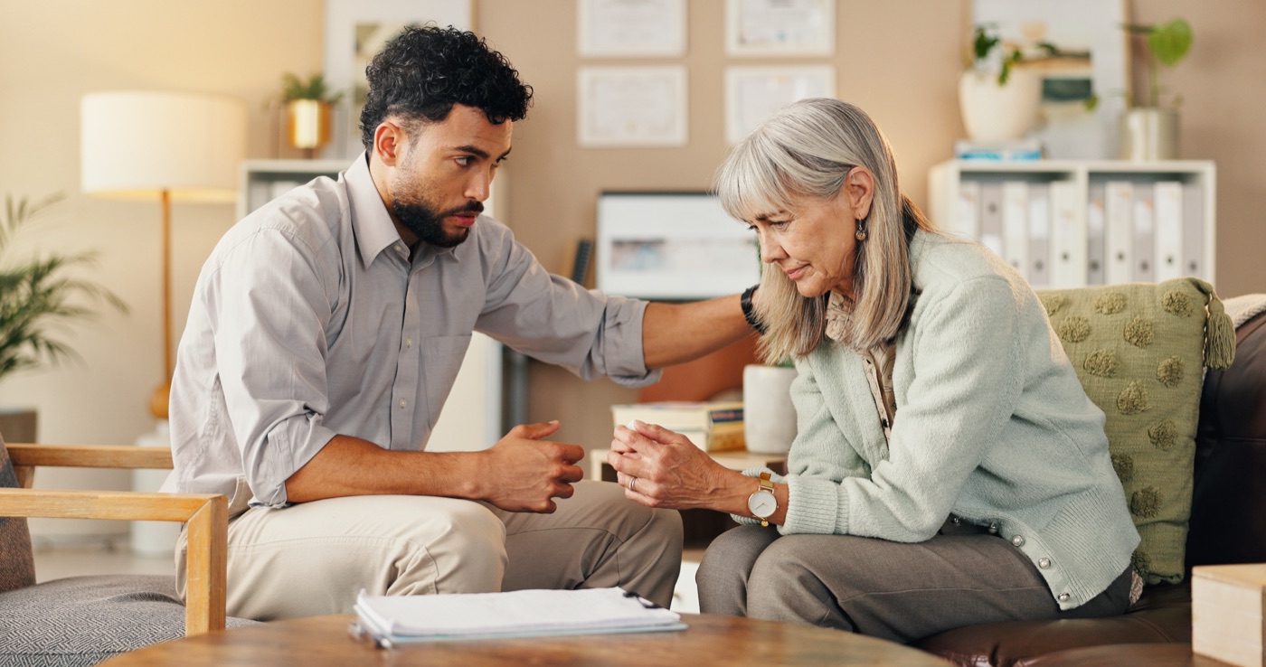 A patient and her care partner going through a stack of paper records