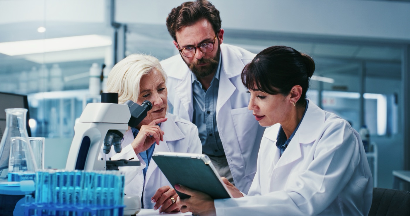 Three researchers reviewing data together in a lab